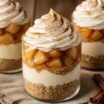 No-bake apple pie cheesecake parfaits layered in cups with crumb crust and whipped topping