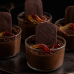 Halloween chocolate graveyard mousse cups with tombstones, cookie crumbs, and gummy worms