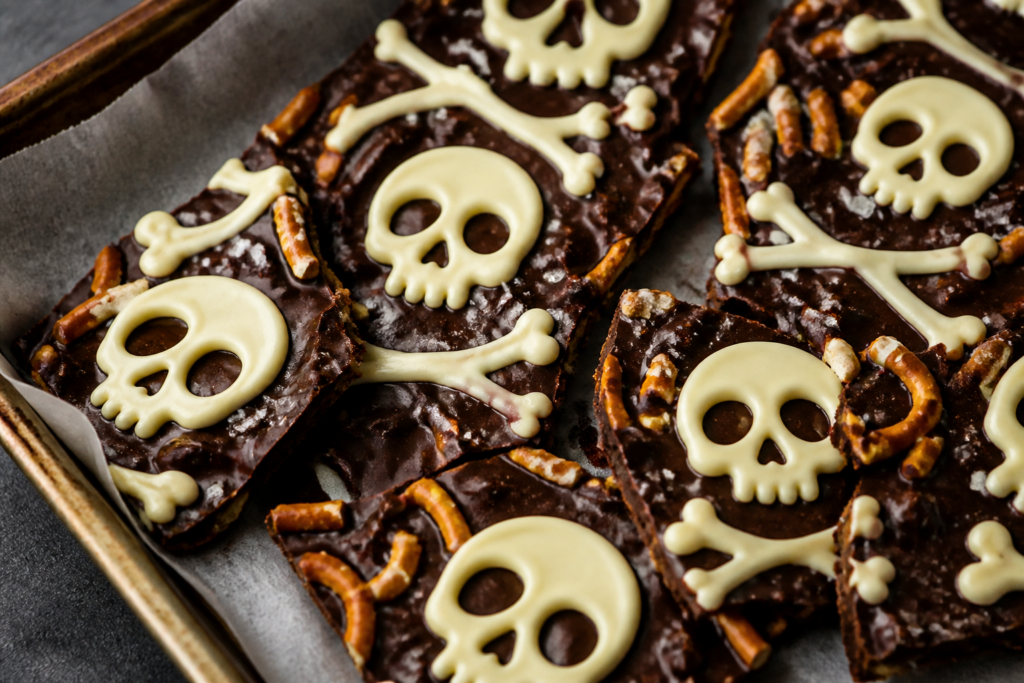 Halloween chocolate skull & bones pretzel bark: dark chocolate sheet with crushed pretzels and white chocolate skull outlines