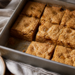 Finished salted brown butter toffee blondies in an 8-inch square pan with golden, imperfect bars