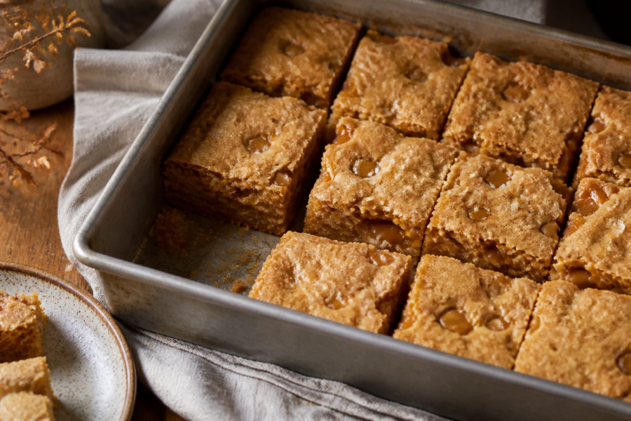 Finished salted brown butter toffee blondies in an 8-inch square pan with golden, imperfect bars
