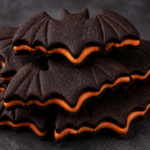 Finished stack of chocolate bat sandwich cookies with orange vanilla cream peeking from the sides