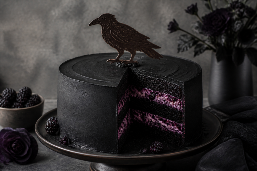 Finished gothic raven blackberry layer cake with black cocoa frosting and tempered chocolate raven silhouette