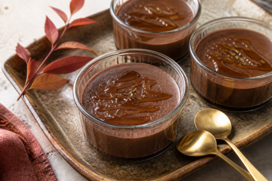 Finished cardamom chocolate pots de crème in ramekins with glossy maple brown-butter drizzle