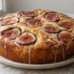 Fresh fig almond olive oil cake with a thin vanilla glaze, glossy streaks down the sides