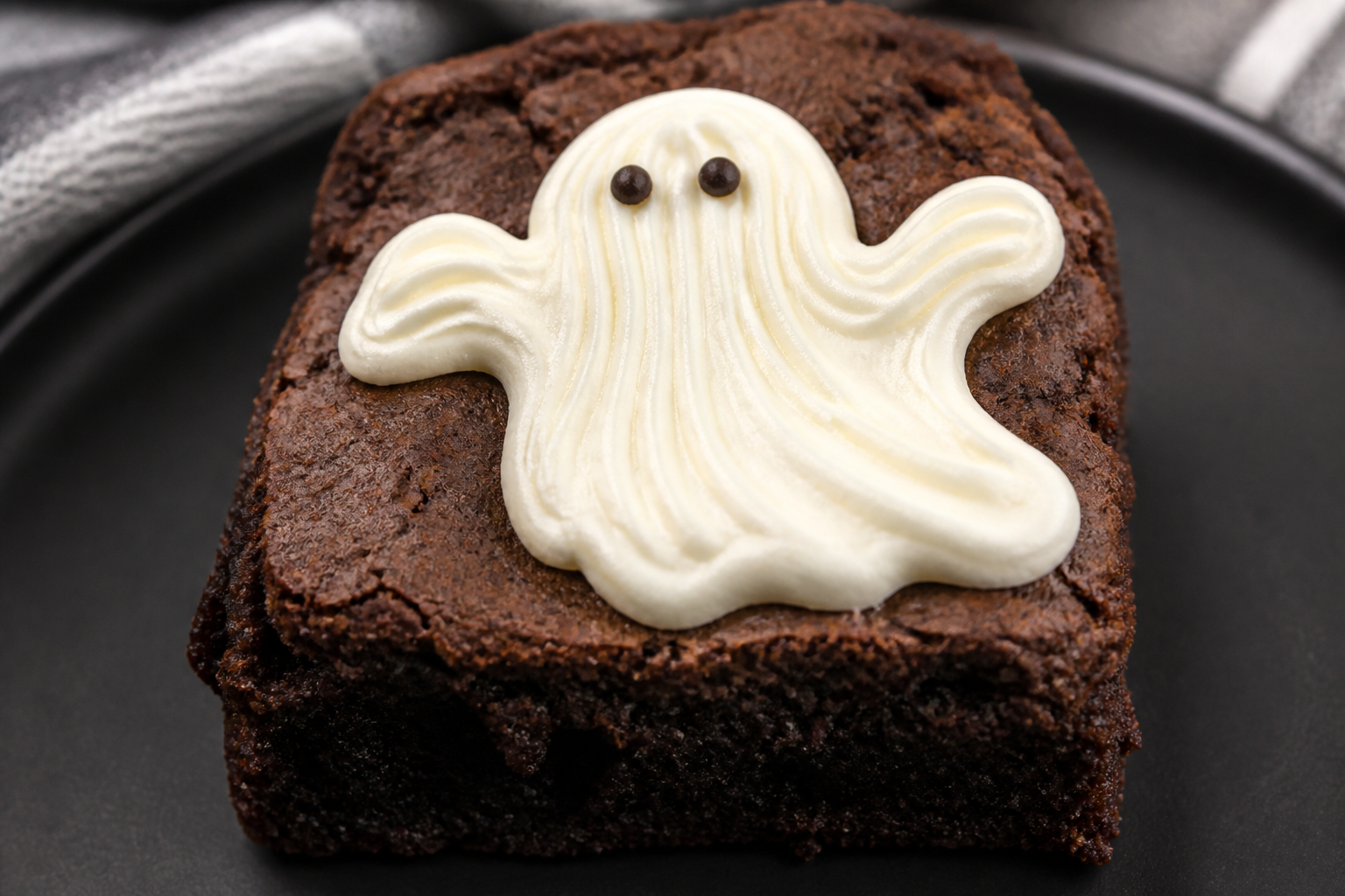 Close-up of a ghost brownie with marshmallow ghost and dot eyes