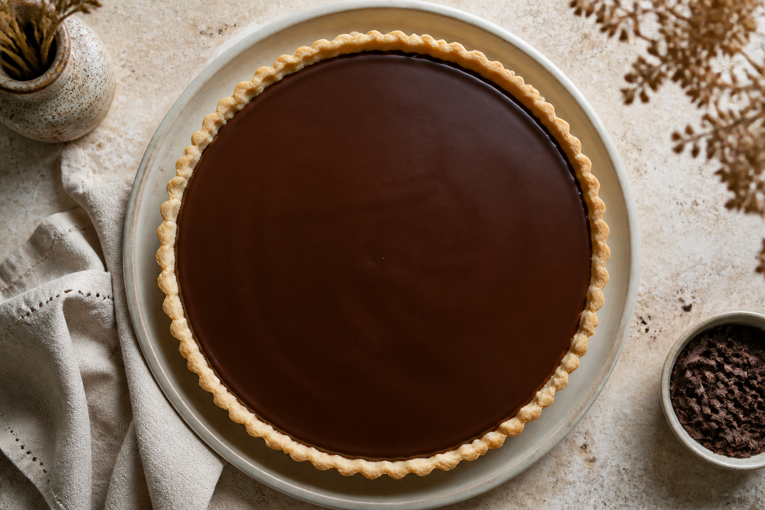 Espresso chocolate ganache covering the caramel tart before chilling
