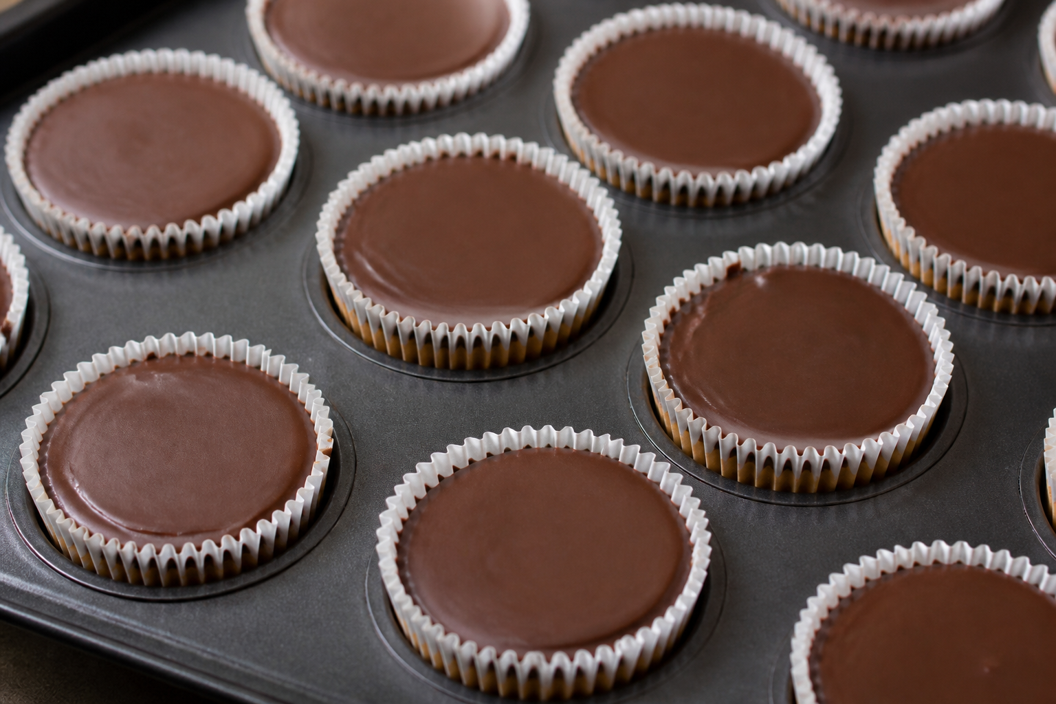 Assembled Halloween peanut butter cups with peanut-butter filling capped in dark chocolate before eyeball details