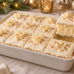 Eggnog tres leches cake with moist vanilla crumb, nutmeg cream, and white chocolate curls.