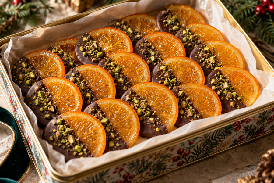 Chocolate covered orange slices with translucent candied citrus and chopped pistachios.