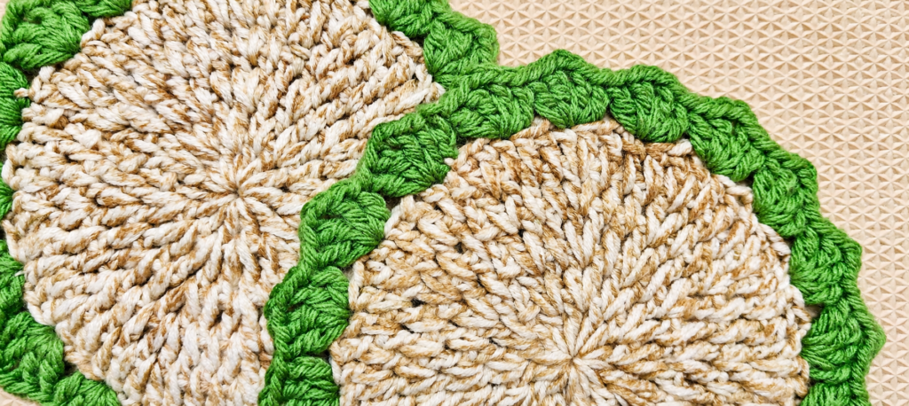 Close view of two completed crochet coasters showing the textured stitches.