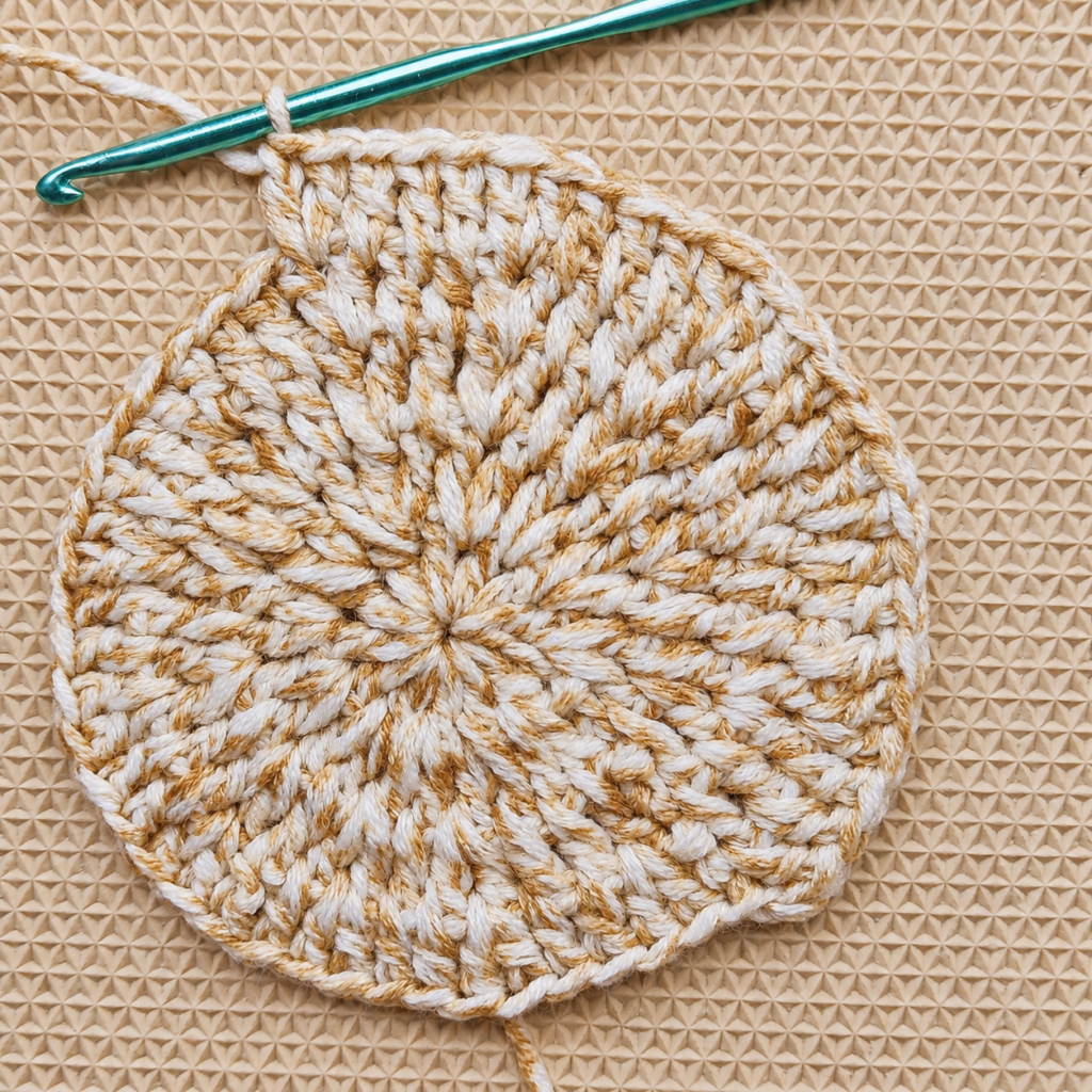 Round 5 crochet circle in progress with a teal crochet hook.