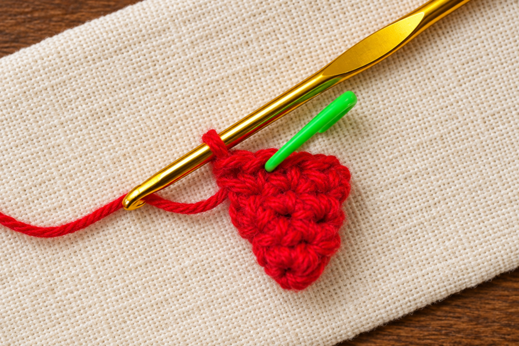 Round 5 of the crochet mini Santa hat ornament showing ten red single crochet stitches.