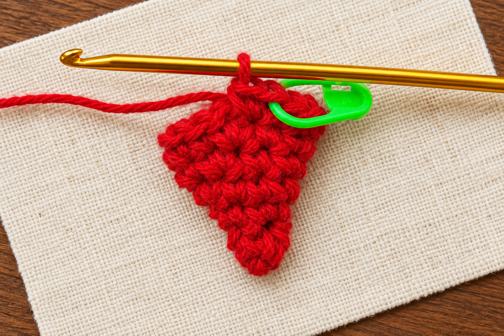 Round 7 of the crochet mini Santa hat ornament showing fourteen red single crochet stitches.